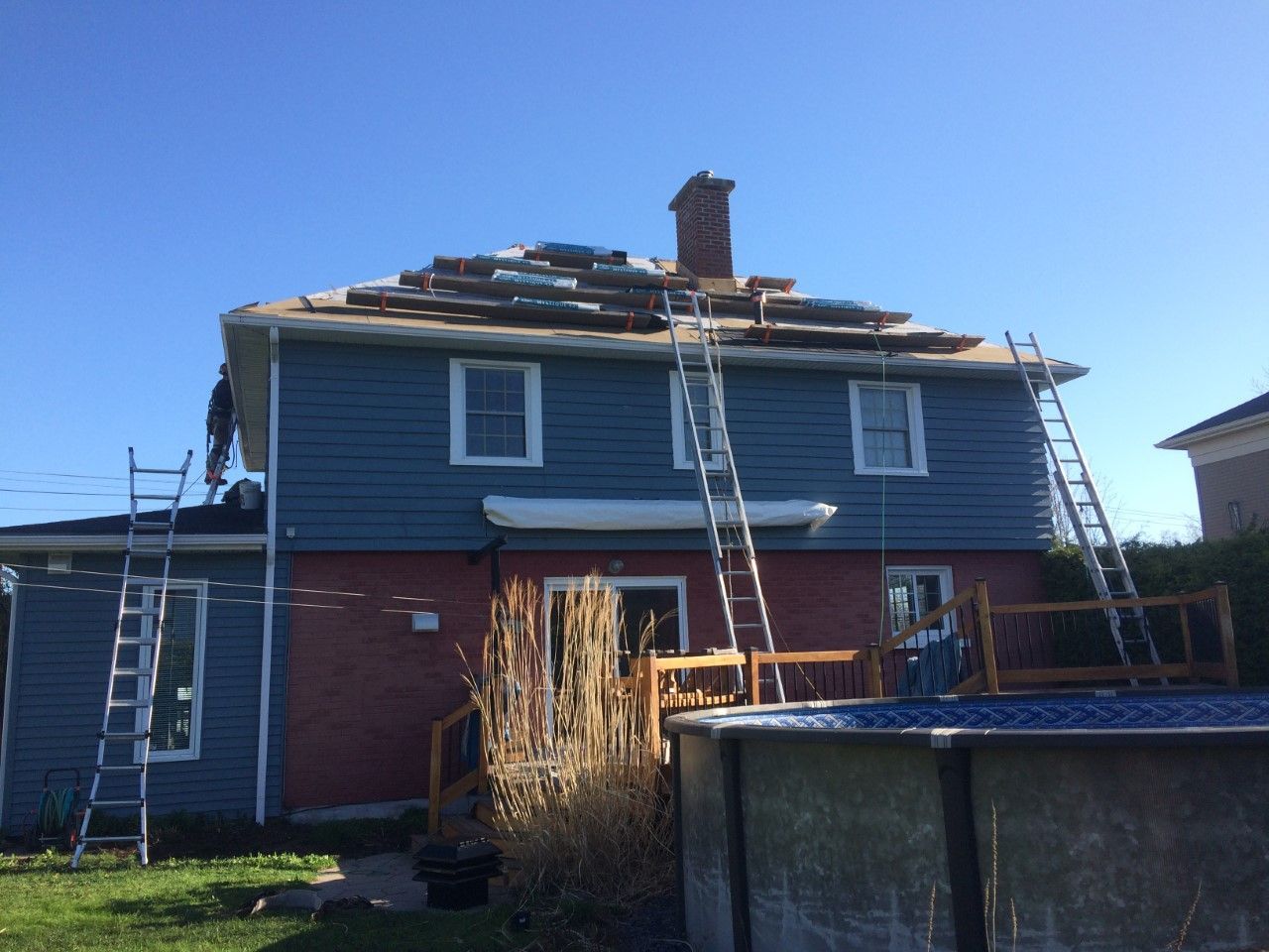 Une maison est en cours de rénovation avec une piscine dans l'arrière-cour.