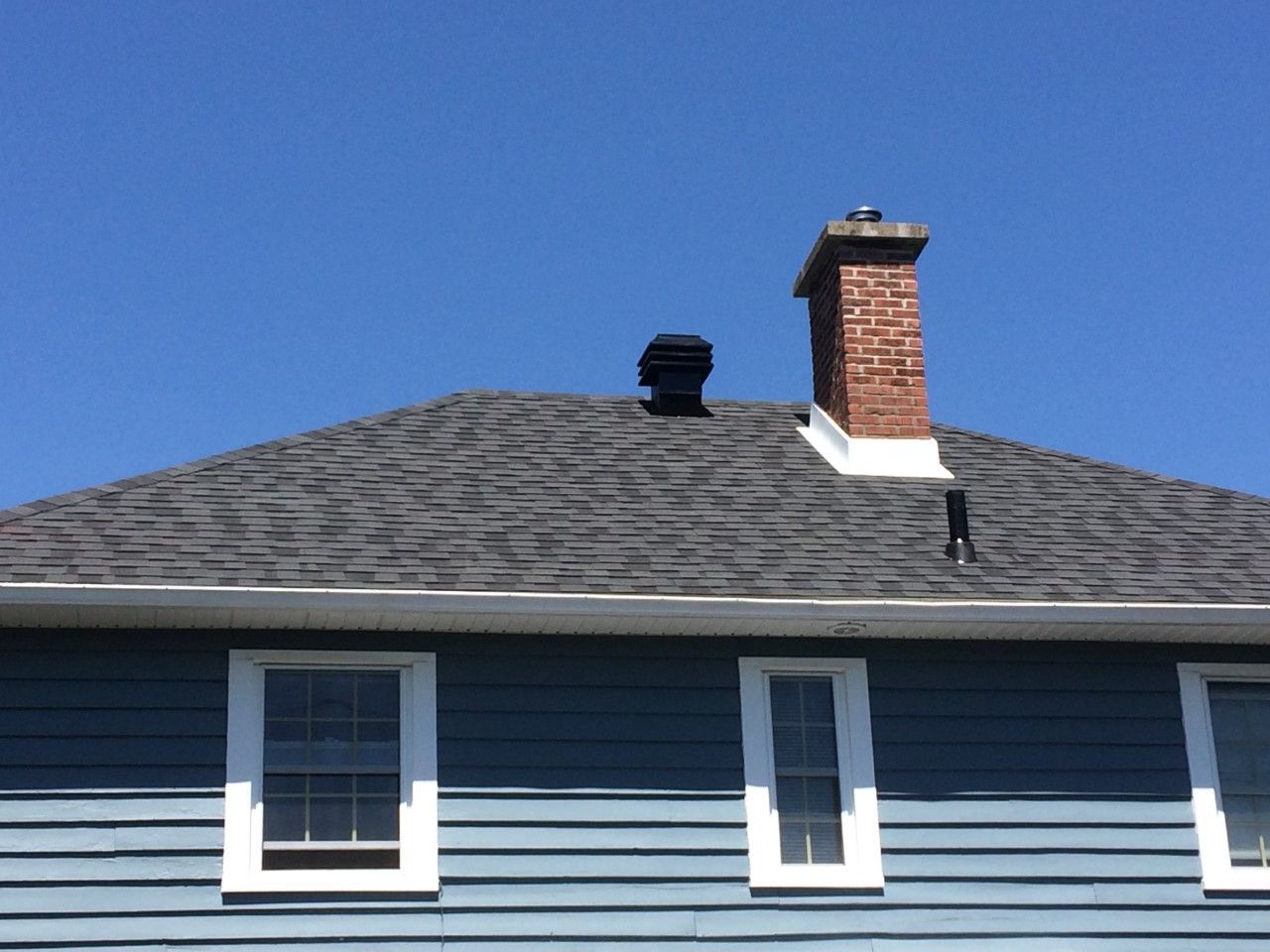 Une maison bleue avec une cheminée sur le toit