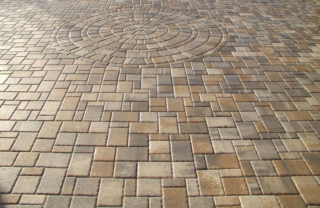 A brick pavement with a circular design in the middle