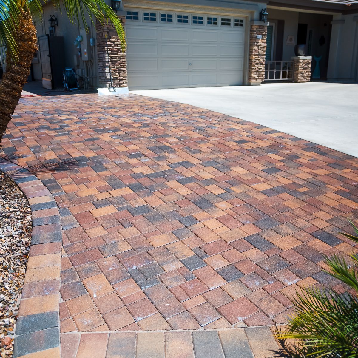 A brick driveway with a grassy area in the background.