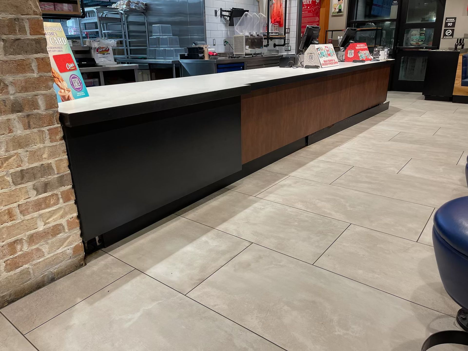 A long counter in a restaurant with a brick wall