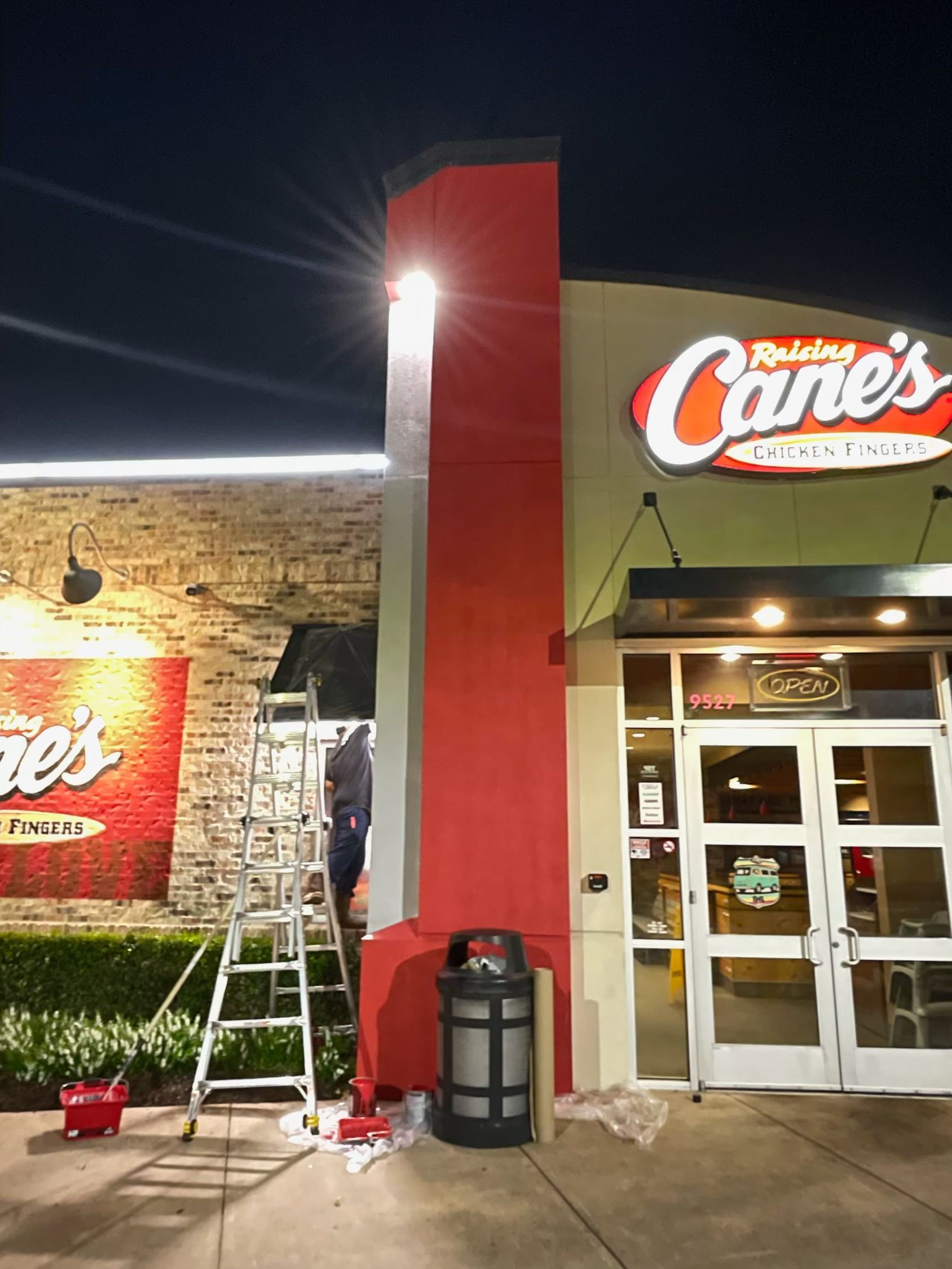 A red and white building with a sign that says ' raising cane 's ' on it