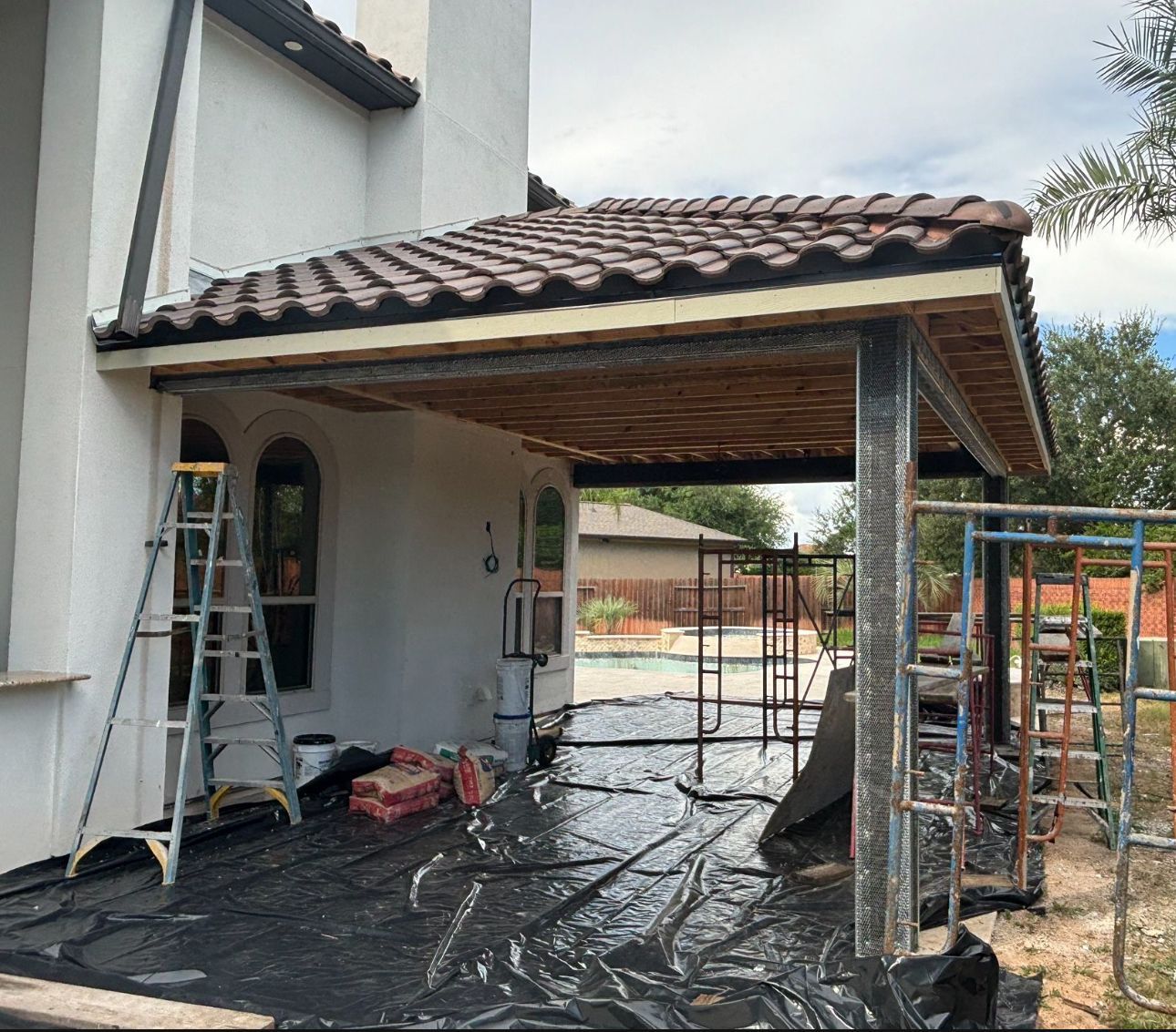 A carport is being built on the side of a house.