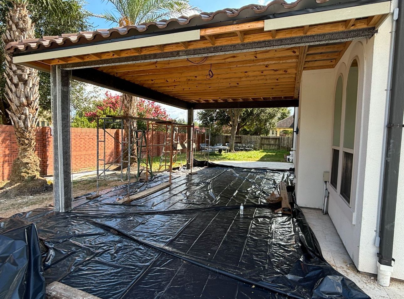 A carport is being built in the backyard of a house.