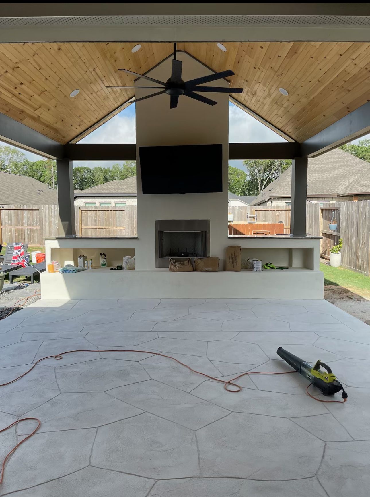 A ceiling fan is hanging from the ceiling above a fireplace.
