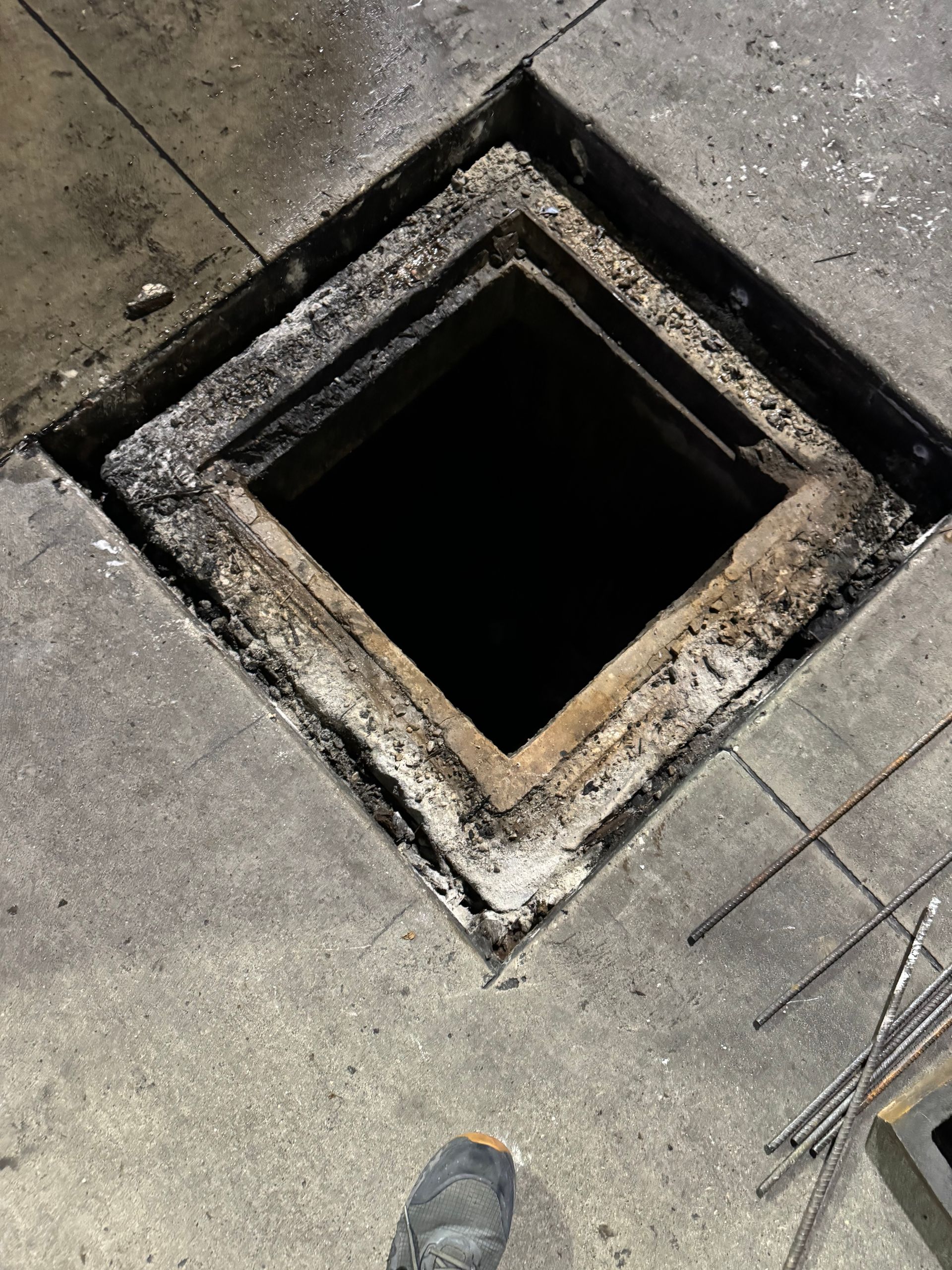 A manhole cover on a sidewalk with a hole in it