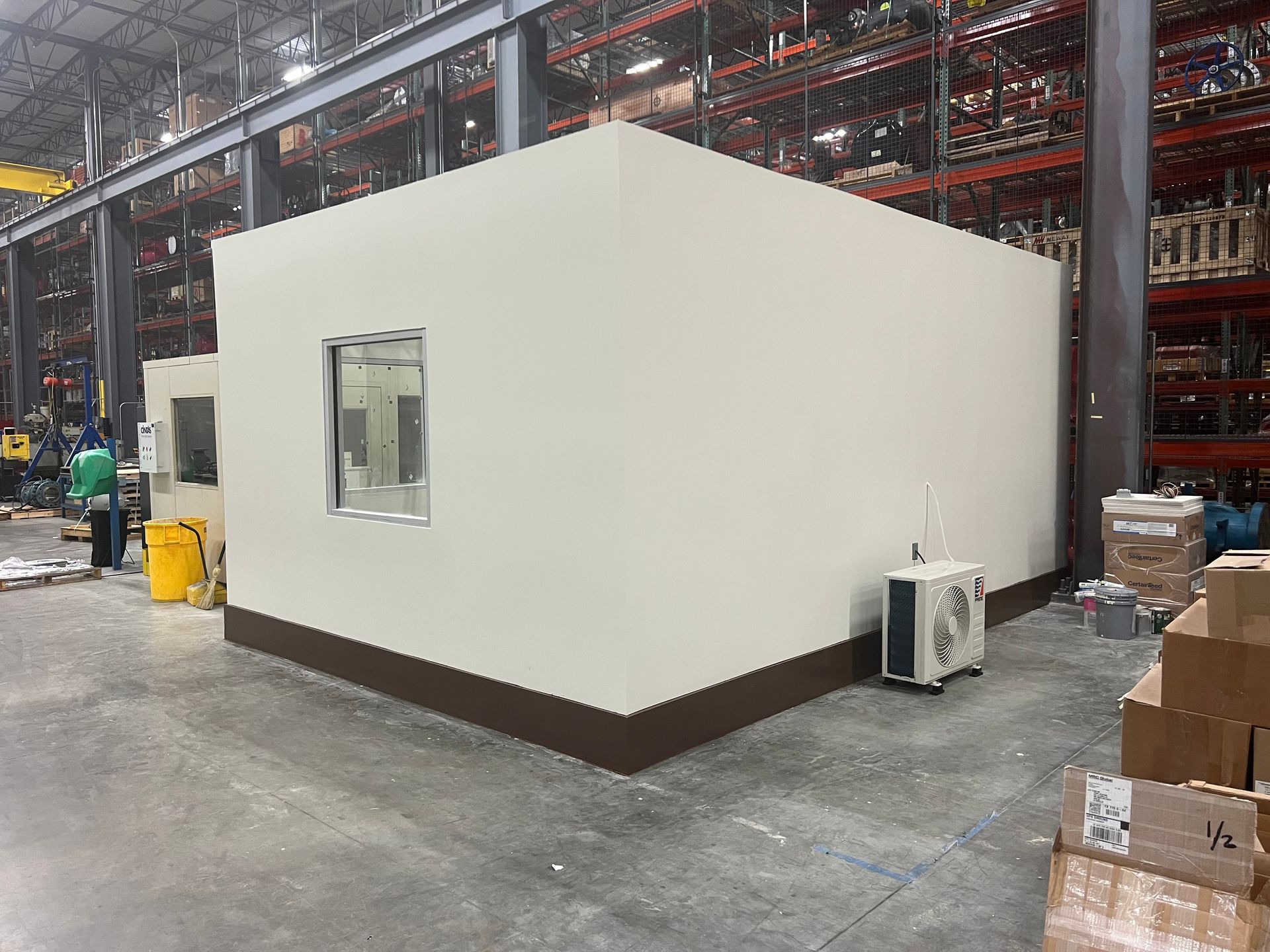 A large white building with a window in a warehouse.