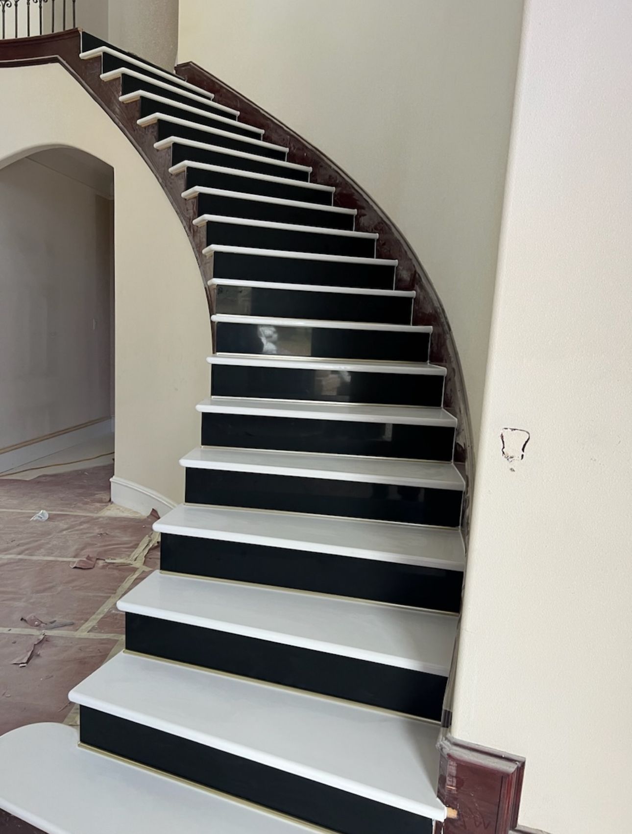 A curved staircase with white steps and black steps