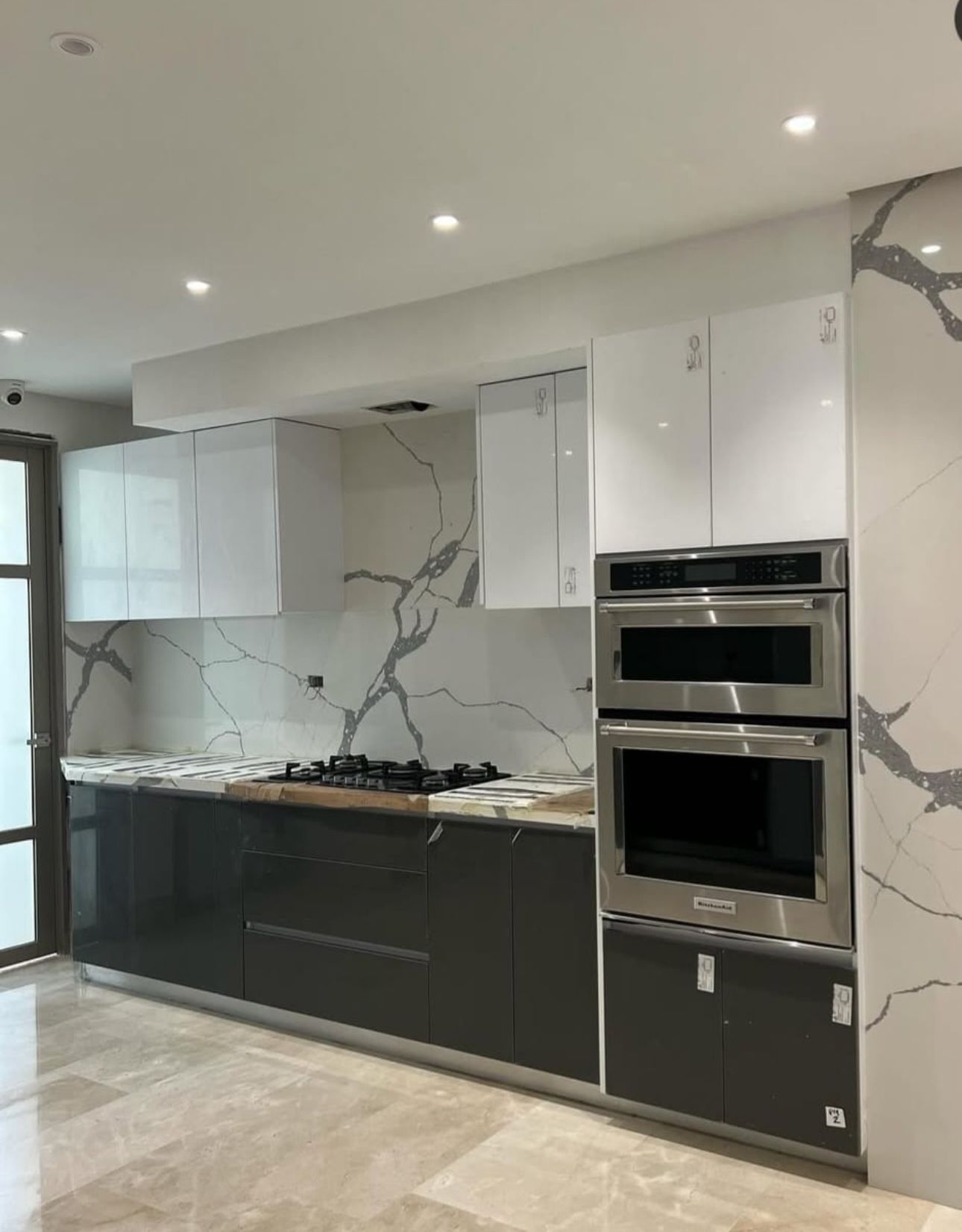 A kitchen with stainless steel appliances and marble counter tops.