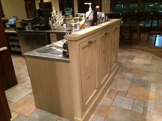 A kitchen counter with a bottle of syrup on it