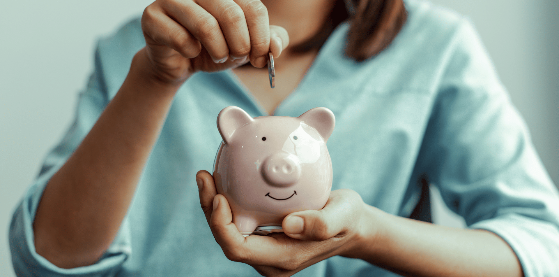 girl putting money into a piggy bank