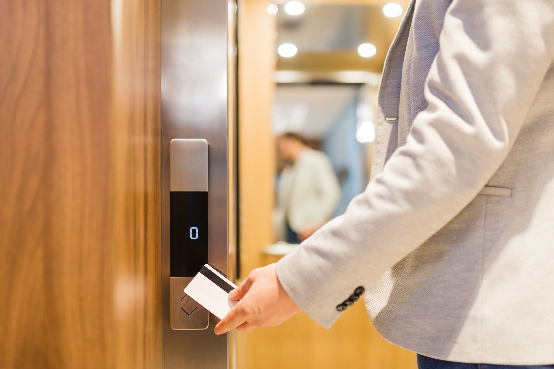 Person swipes key card by elevator door to access the elevator. Person swipes key card by elevator door to access the elevator.