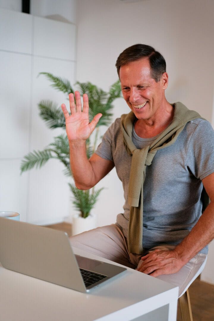 A man is sitting at a desk using a laptop computer.