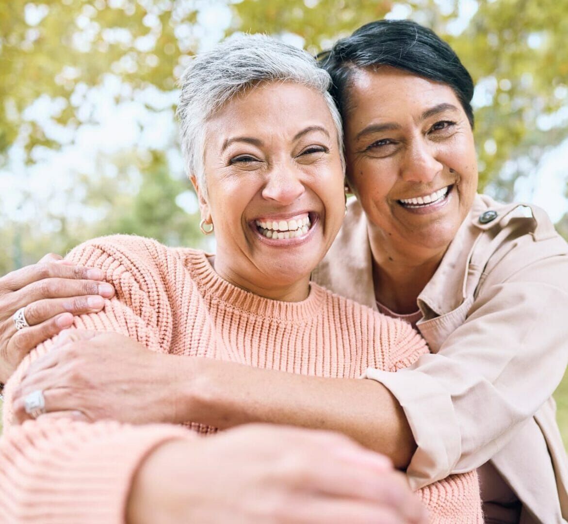 Two women are hugging each other and smiling for the camera.