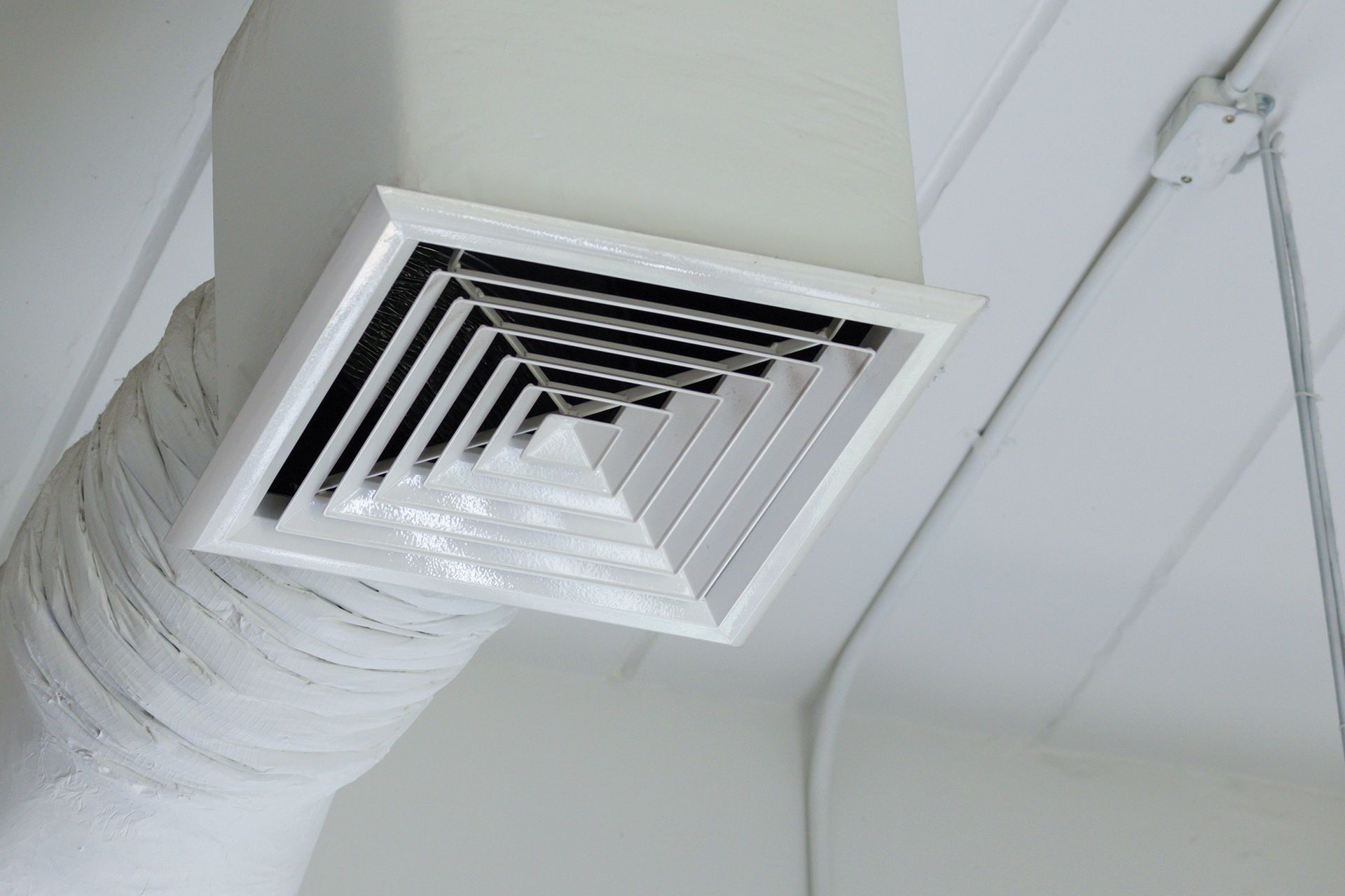A close up of an air vent on the ceiling of a building.