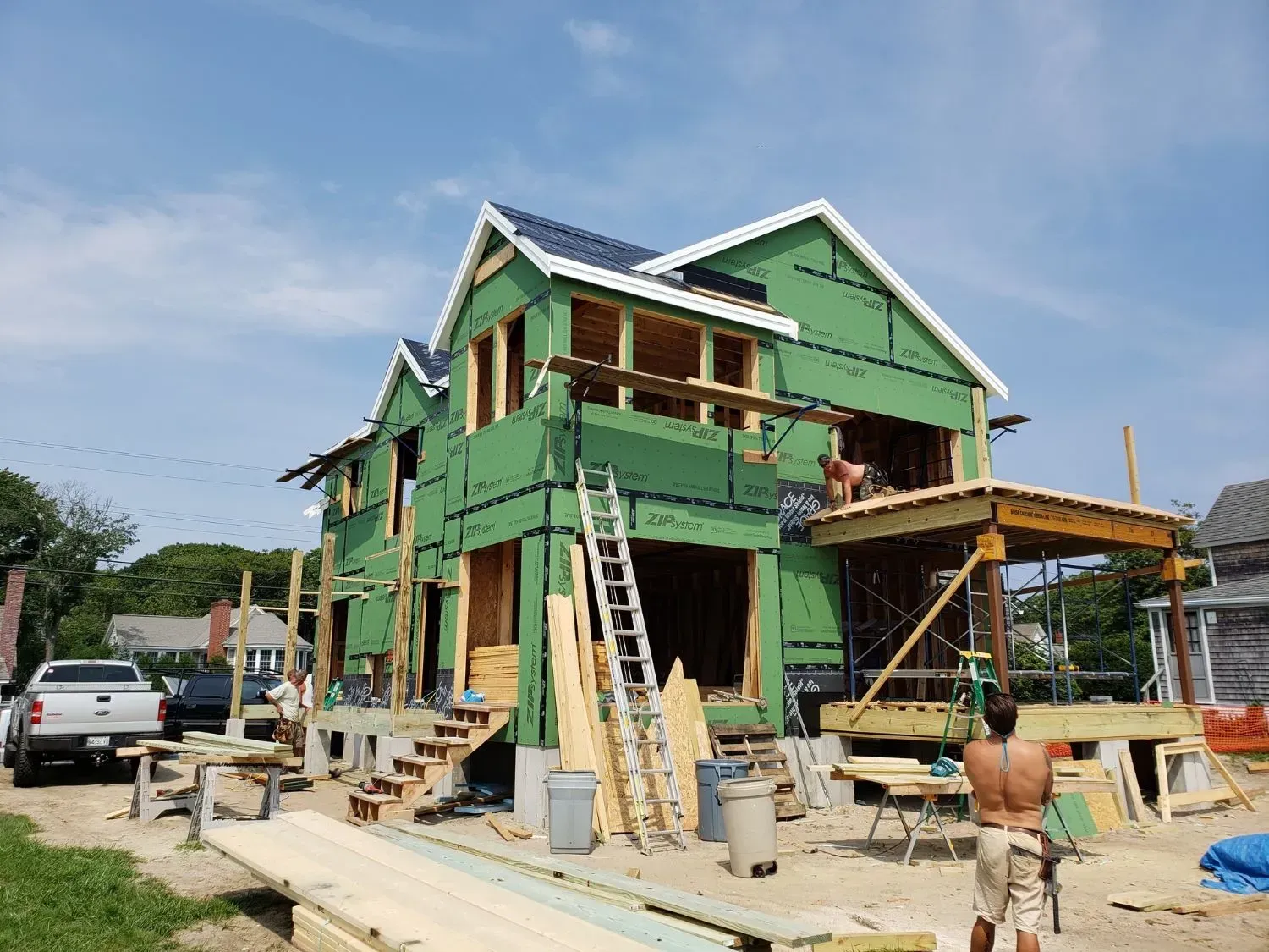 A man is standing in front of a house under construction.
