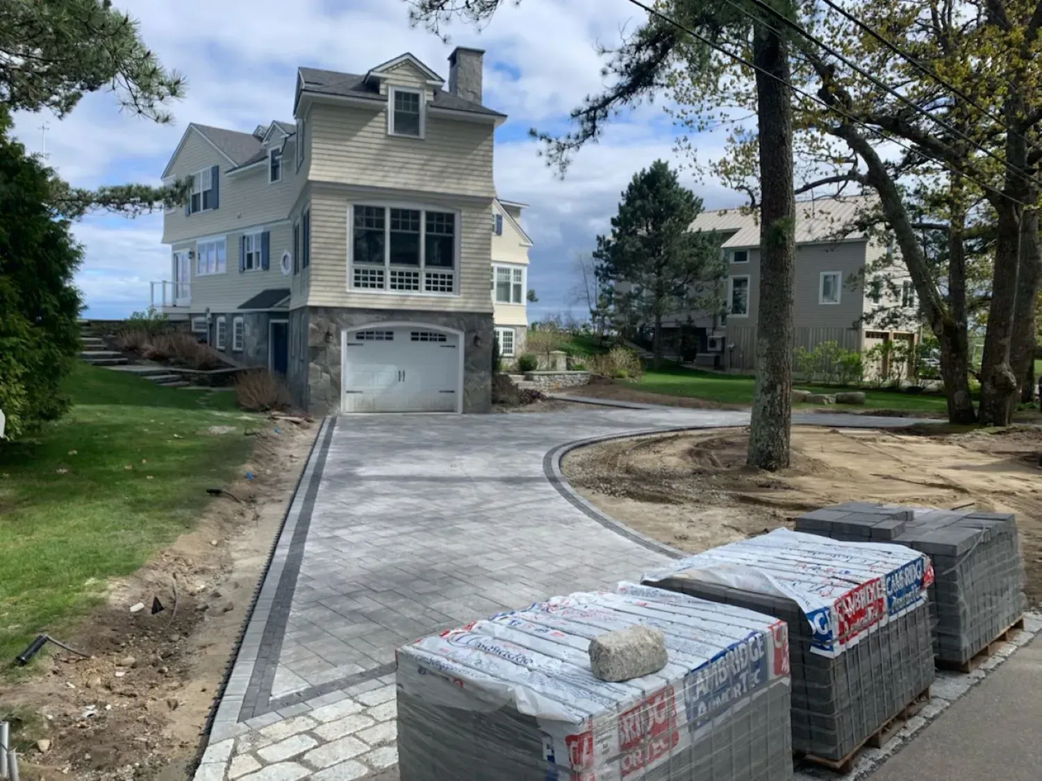 A large house with a driveway being built in front of it.