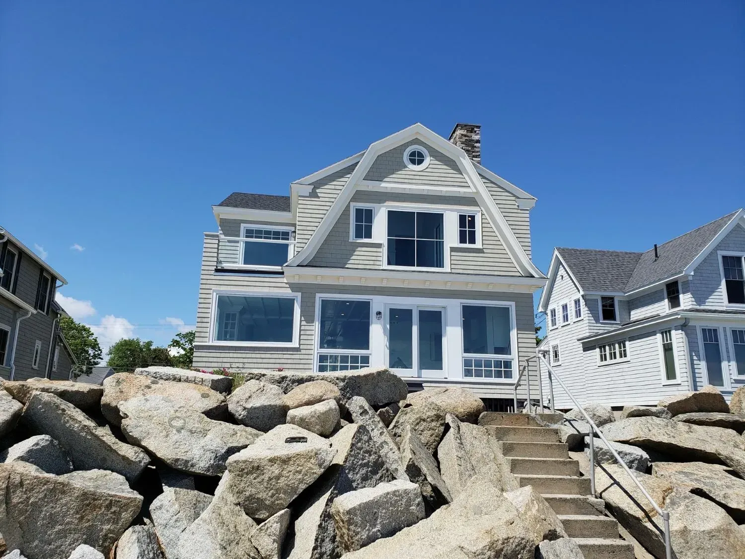 A large house is sitting on top of a rocky hill.