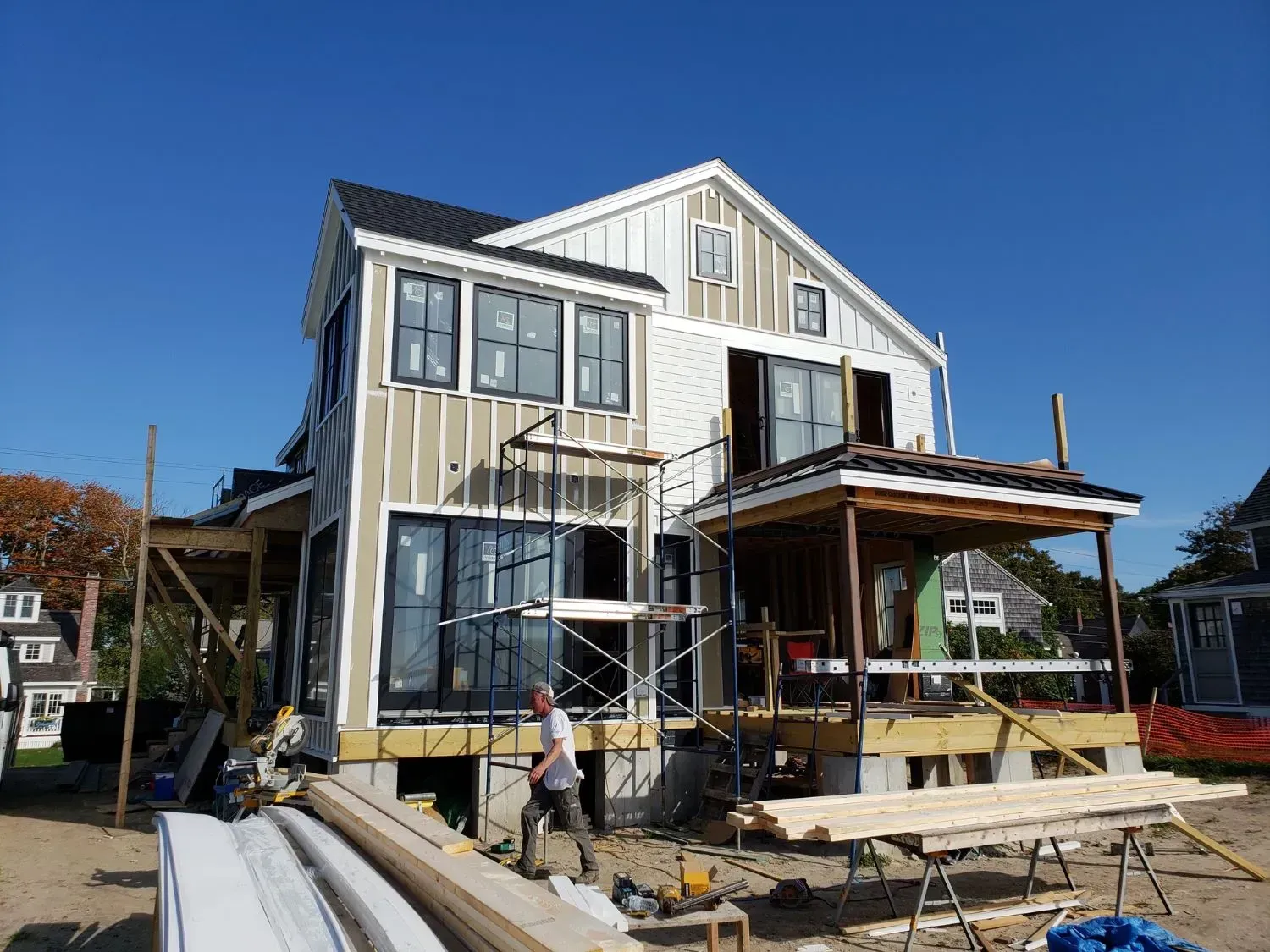 A man is standing in front of a house that is being built.
