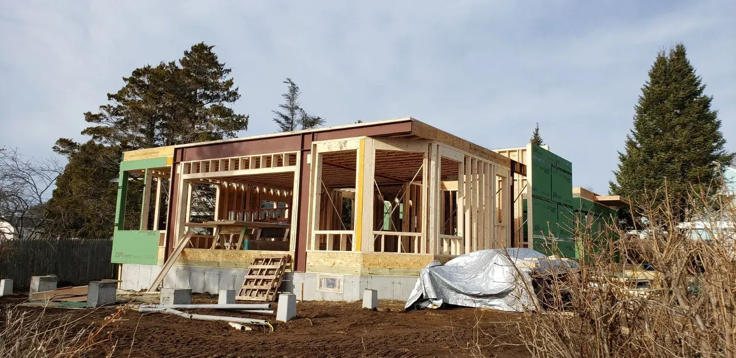 A house is being built in the middle of a dirt field.