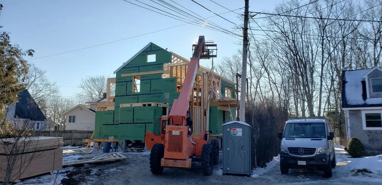 A house is being built in a snowy neighborhood.