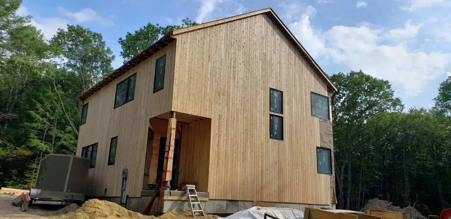 A wooden house is being built in the middle of a forest.