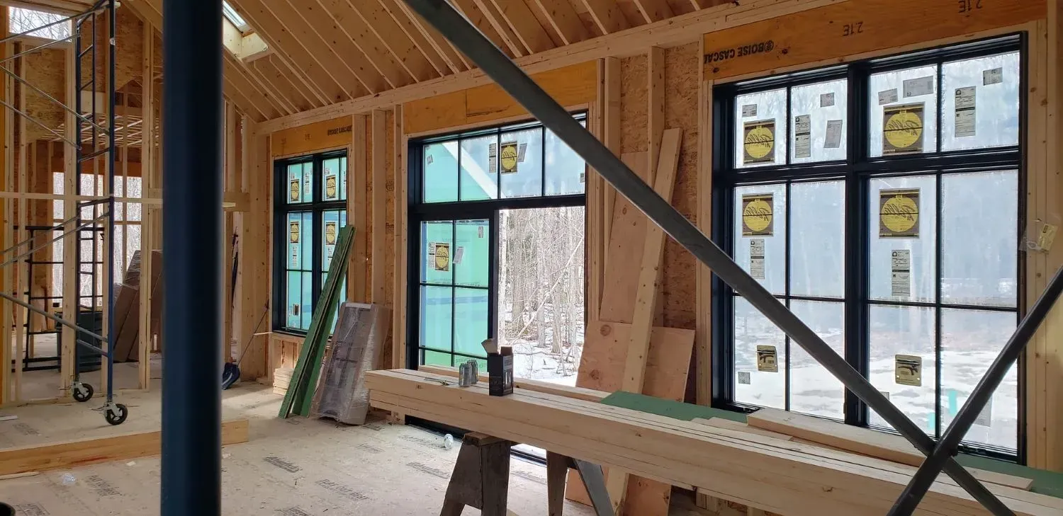 The inside of a house under construction with a lot of windows.