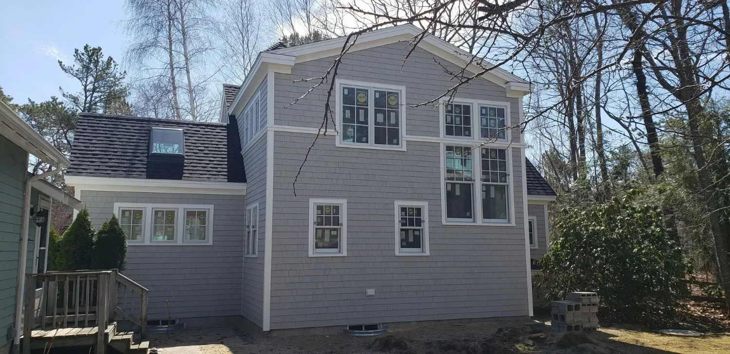 A large house with a lot of windows is surrounded by trees.