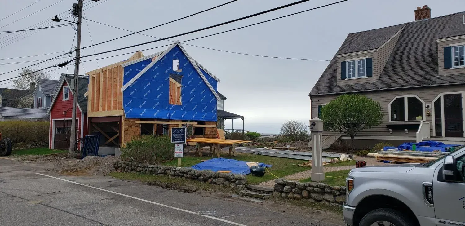 A truck is parked in front of a house under construction.