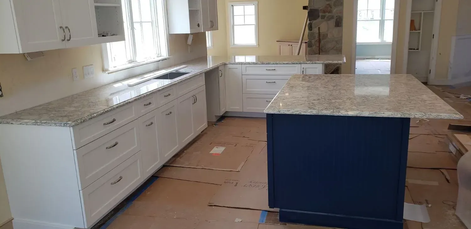 A kitchen with white cabinets and granite counter tops is being remodeled.
