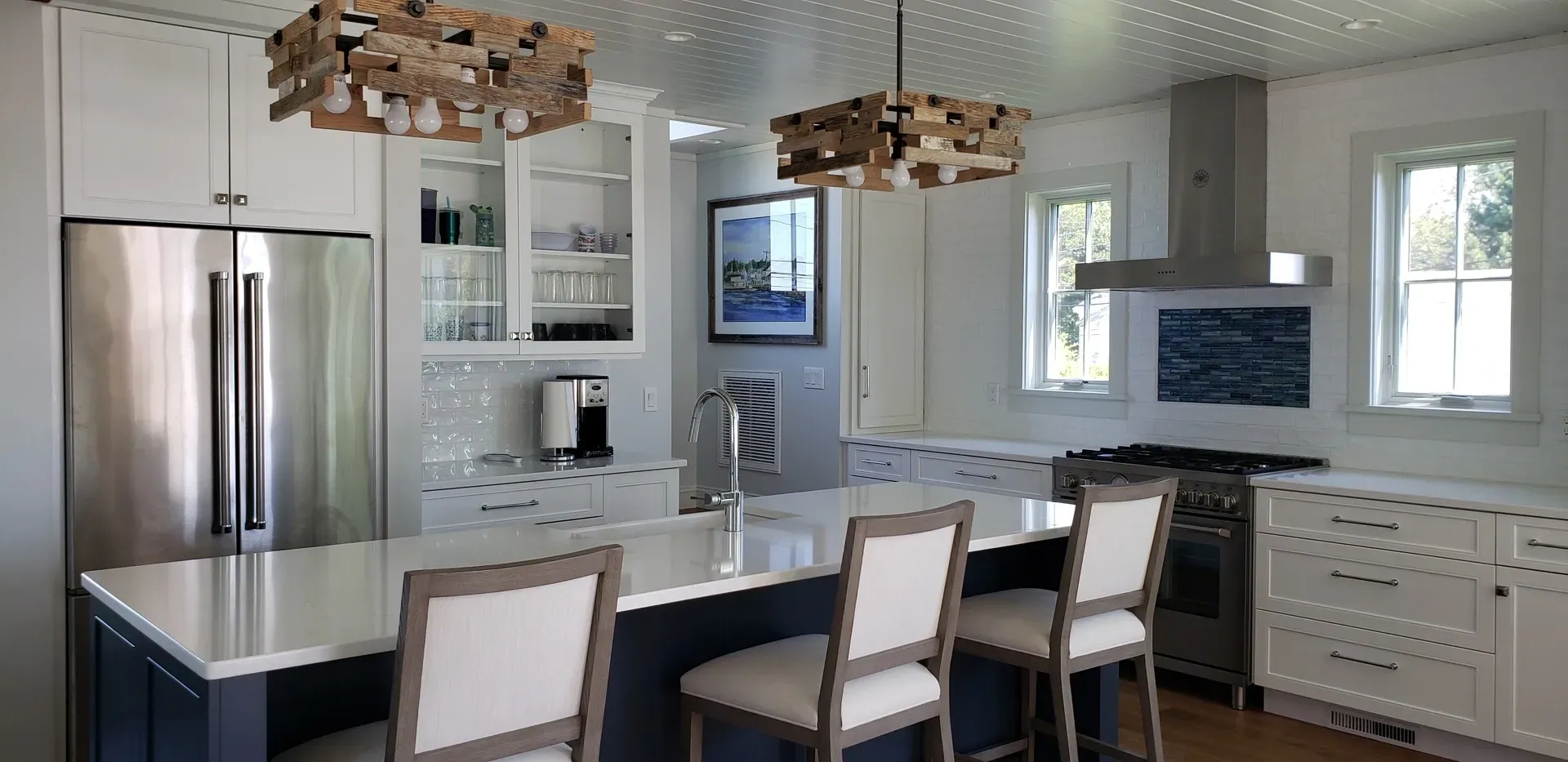 A kitchen with stainless steel appliances , white cabinets , and a large island.