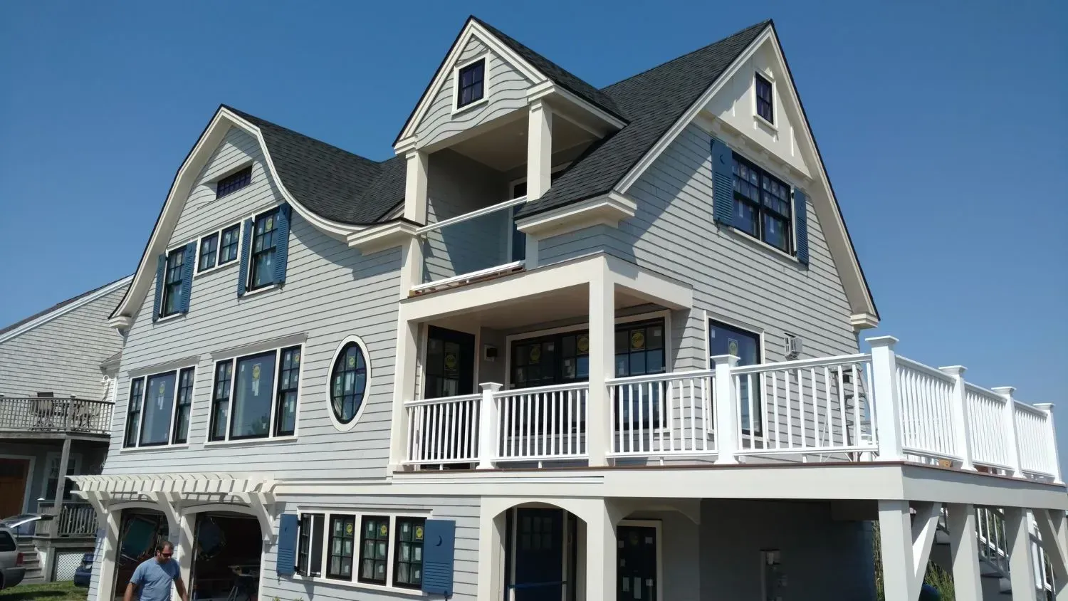 A large white house with a balcony and blue shutters