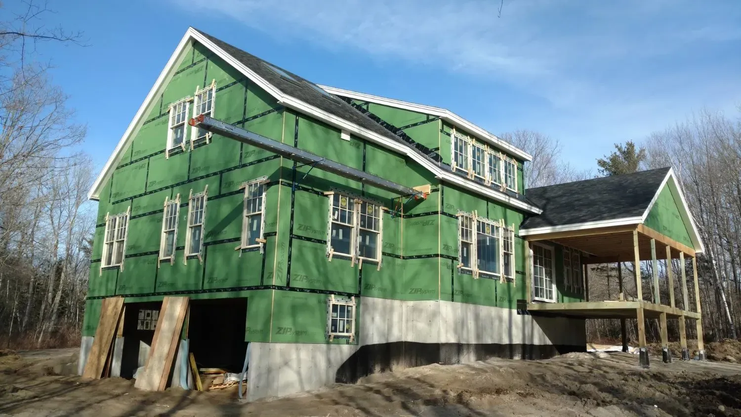 A large green house is being built in the middle of a forest.