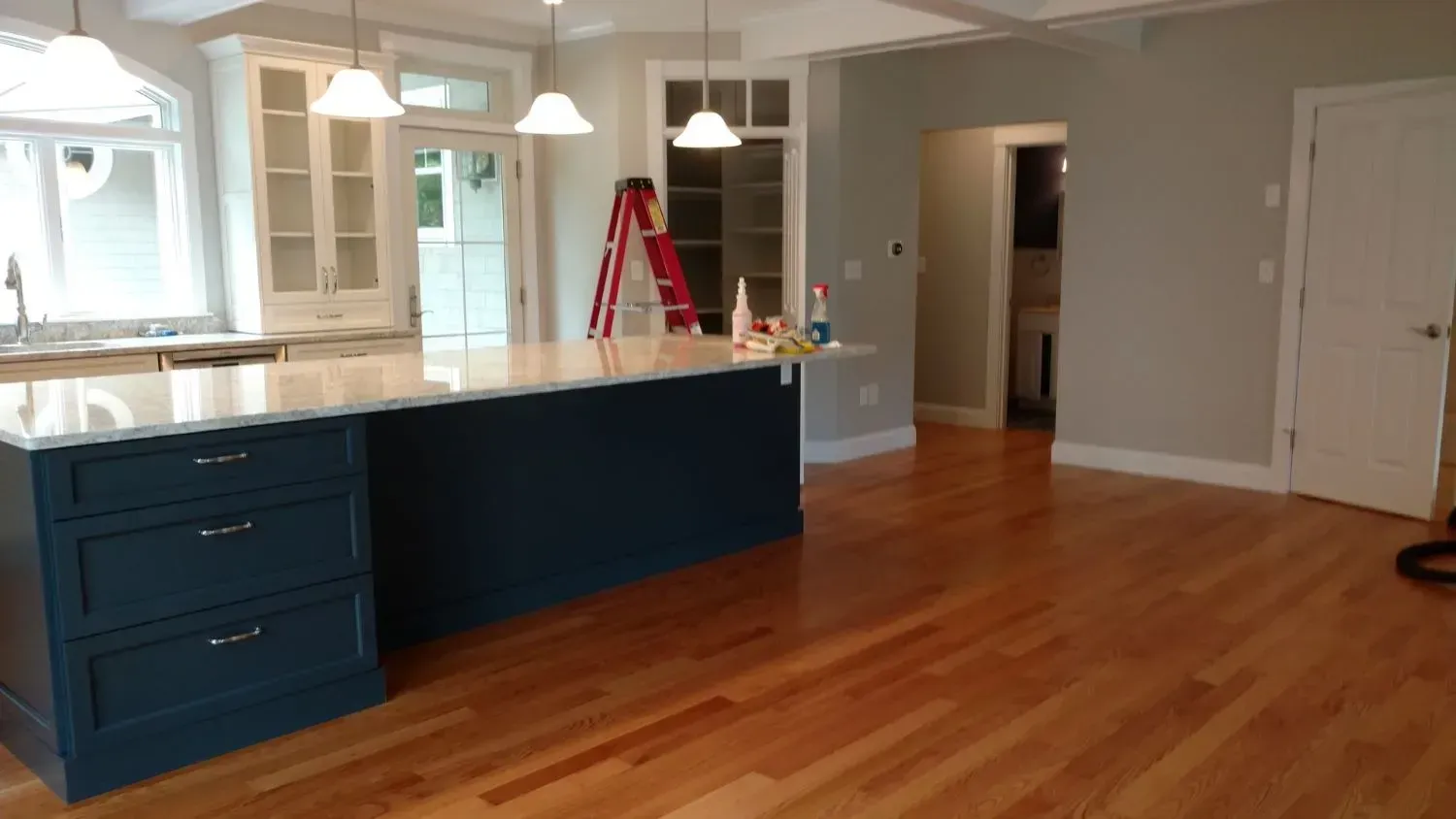 A kitchen with a large island and hardwood floors