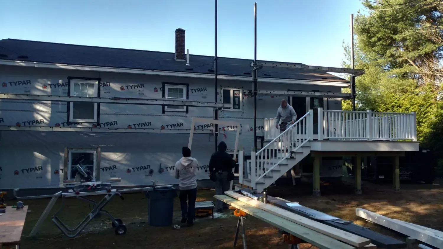 A group of people are working on the side of a house.