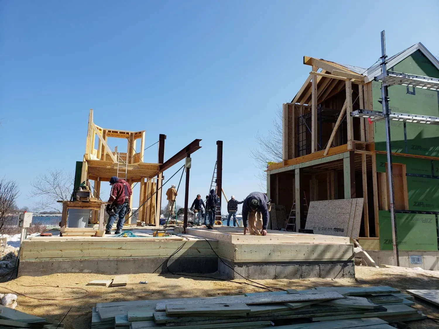 A group of construction workers are working on a house under construction.