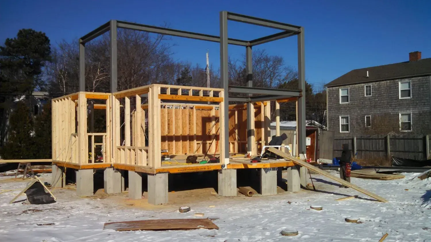 A house is being built in the snow in front of a building.