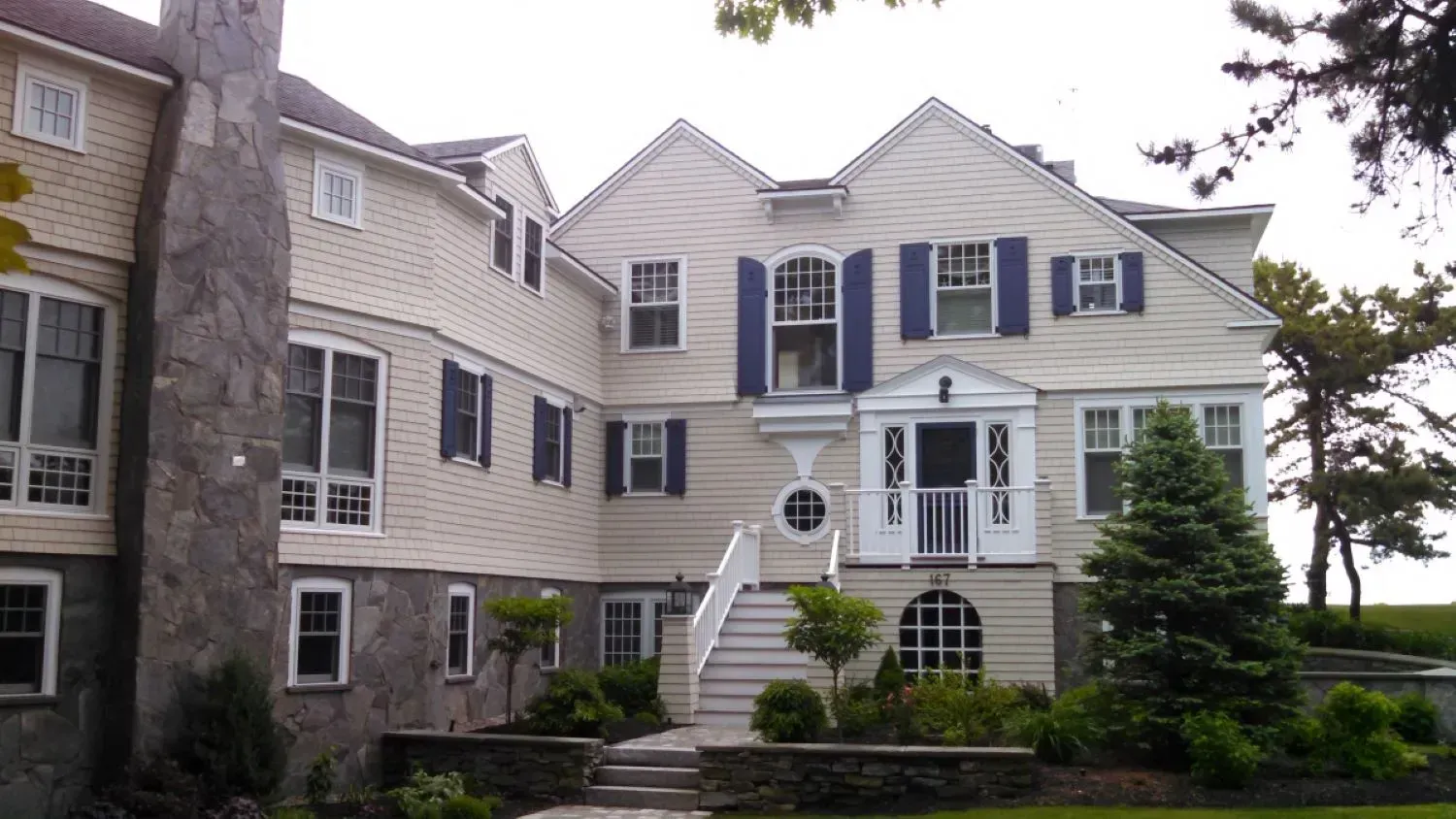 A large white house with blue shutters on the windows