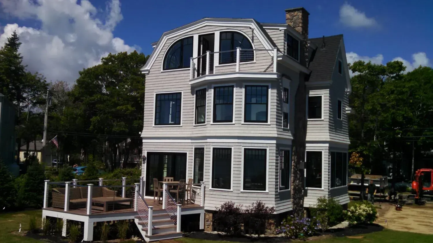 A large white house with a large deck in front of it