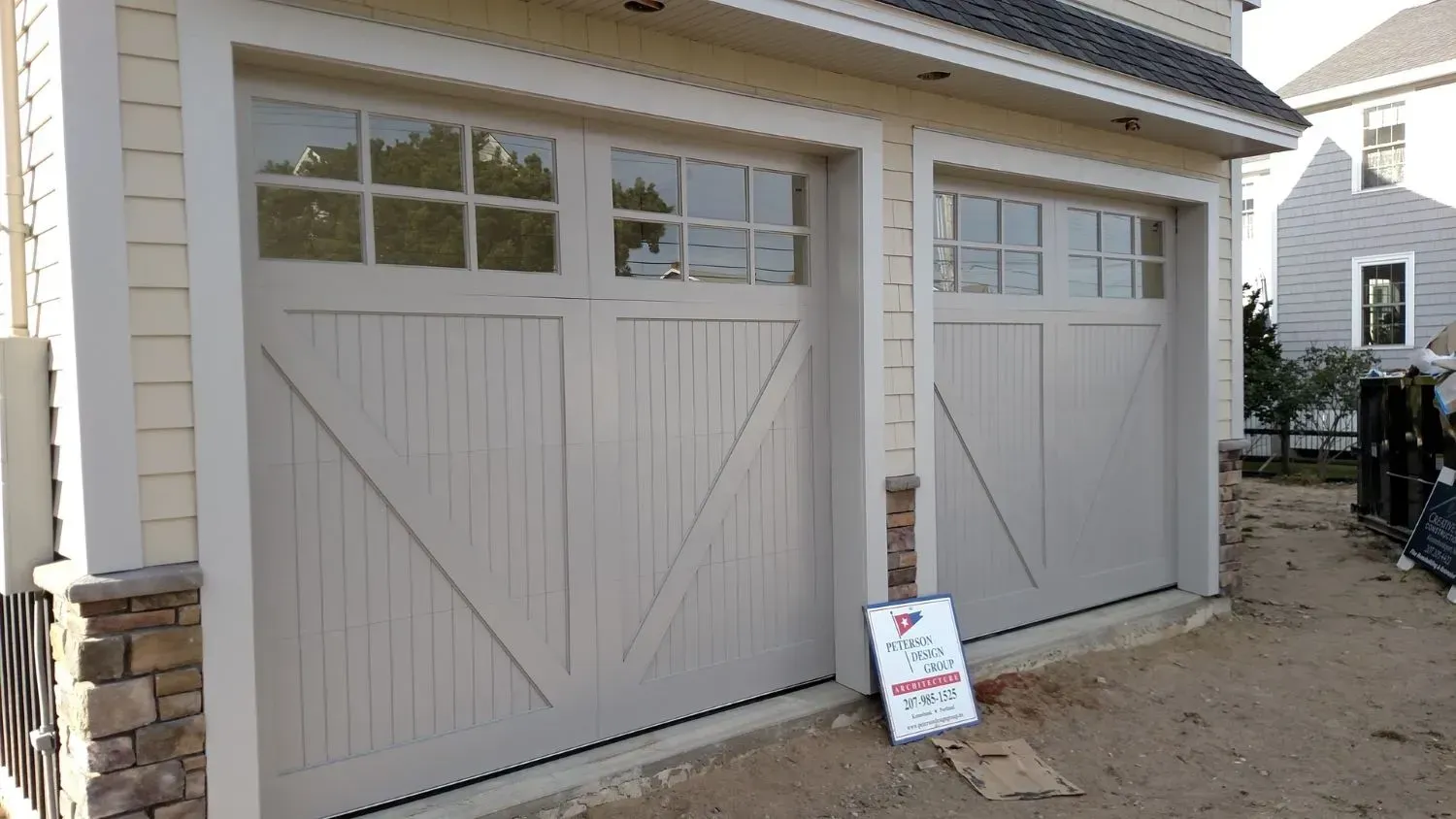 A house with two garage doors and a sign that says no parking