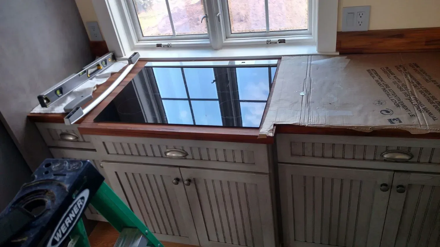 A stove top oven is being installed in a kitchen