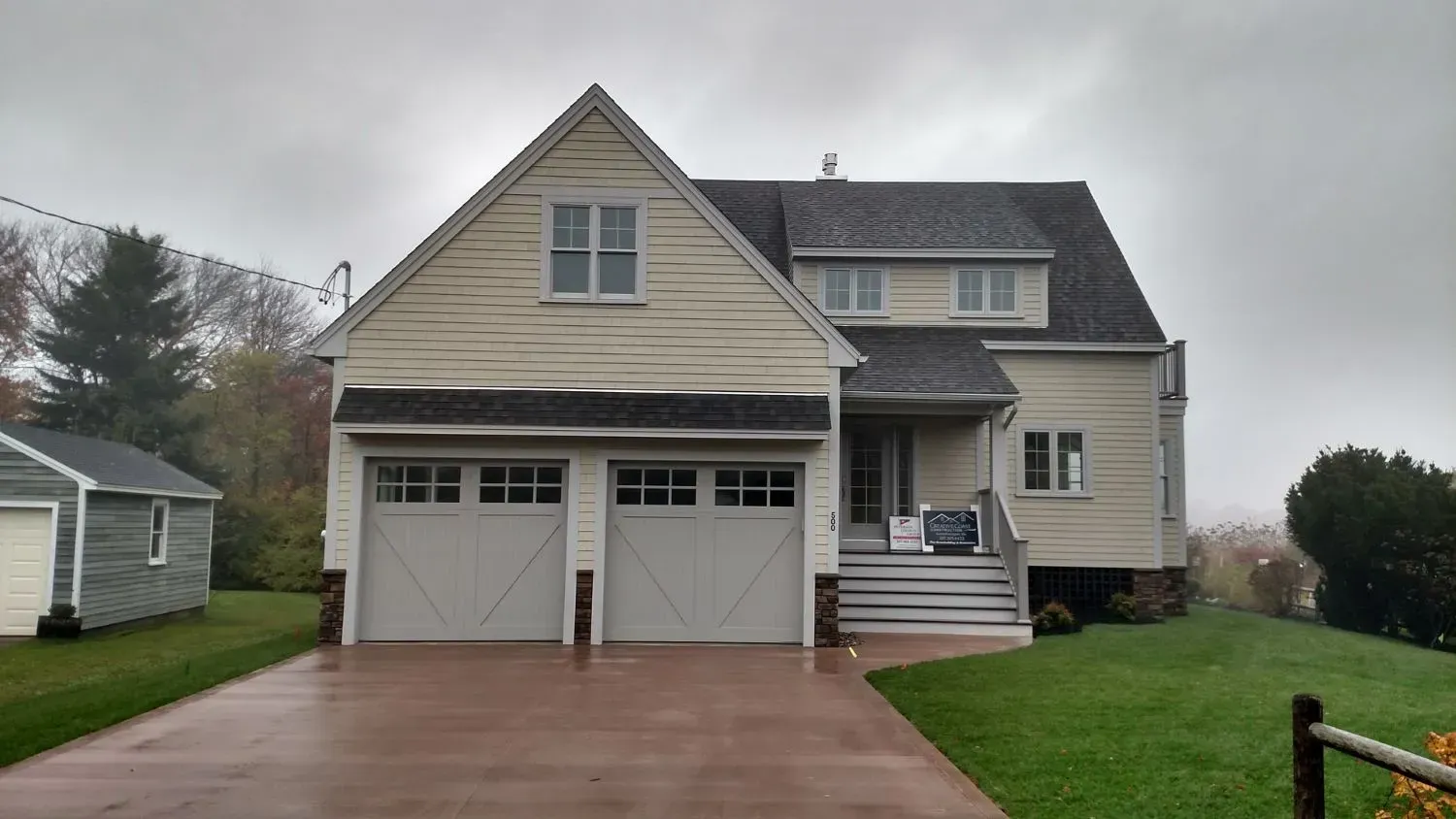 A large house with two garage doors and a driveway