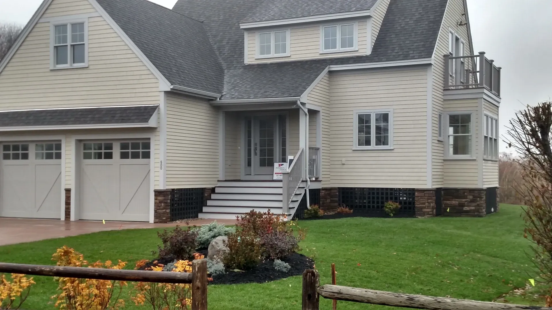 A large white house with a wooden fence in front of it
