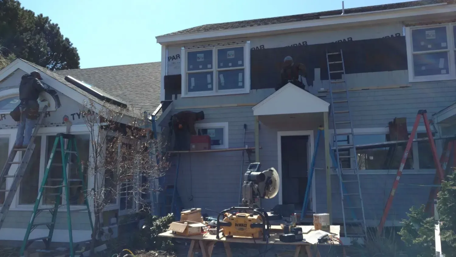 A house is being remodeled by a group of people.