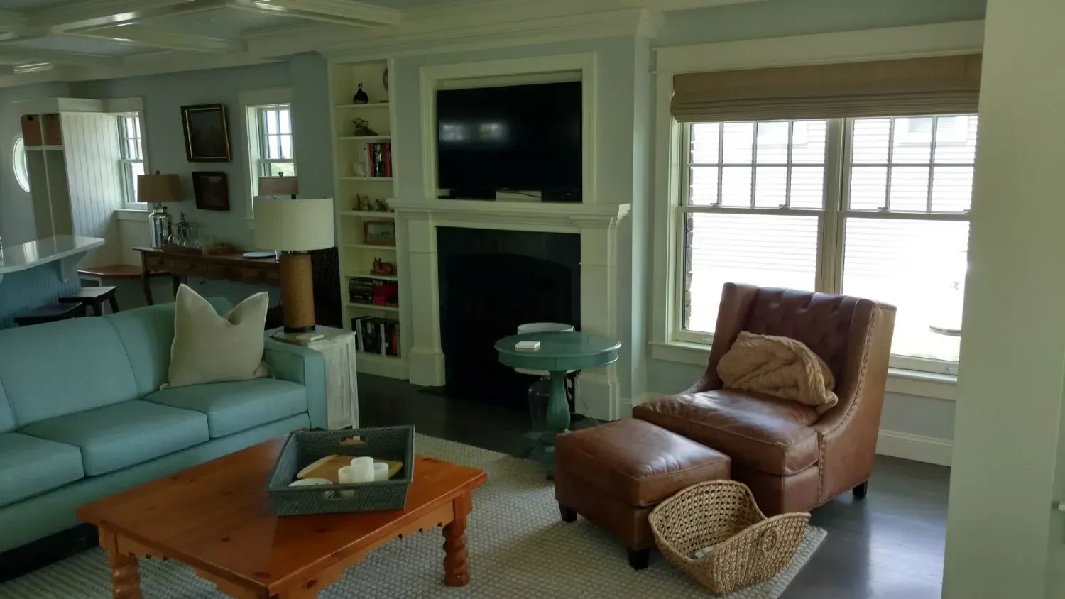 A living room with a couch , chair , coffee table and fireplace