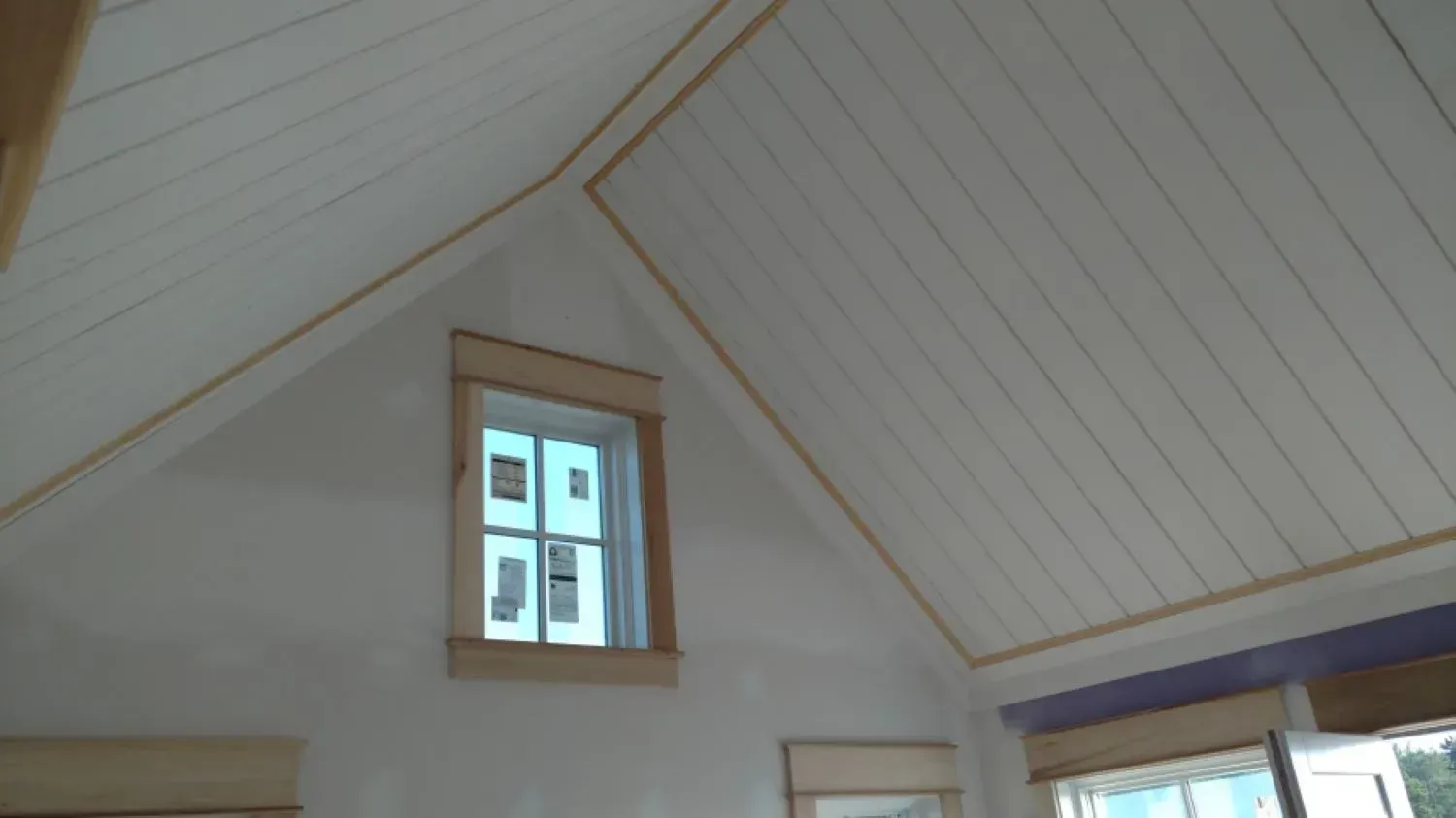 A room with a vaulted ceiling and a window