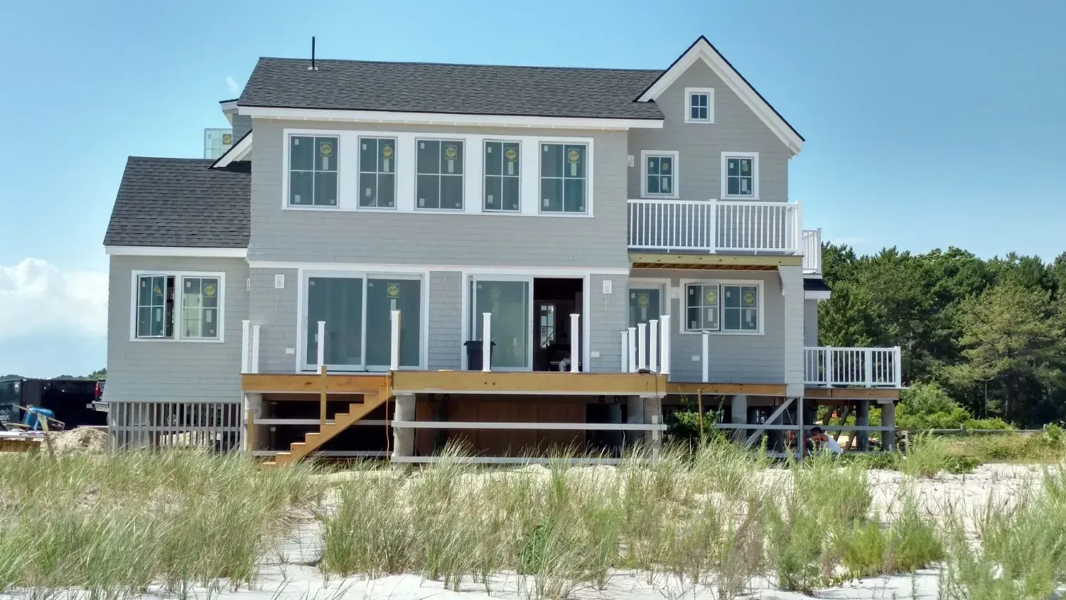 A large house is sitting on top of a sandy beach.