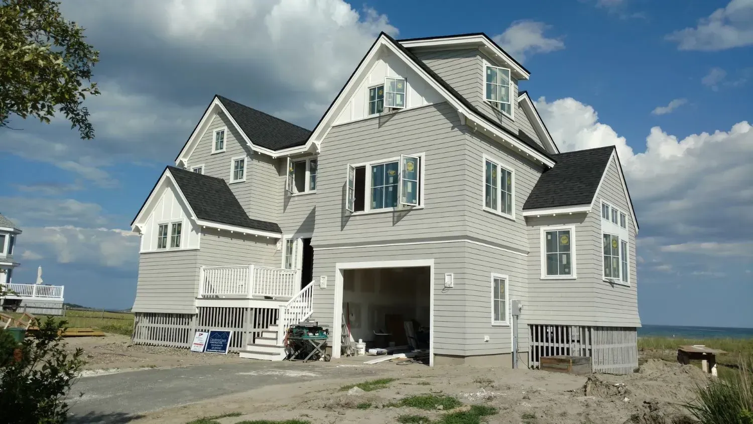 A large white house with a black roof and a garage
