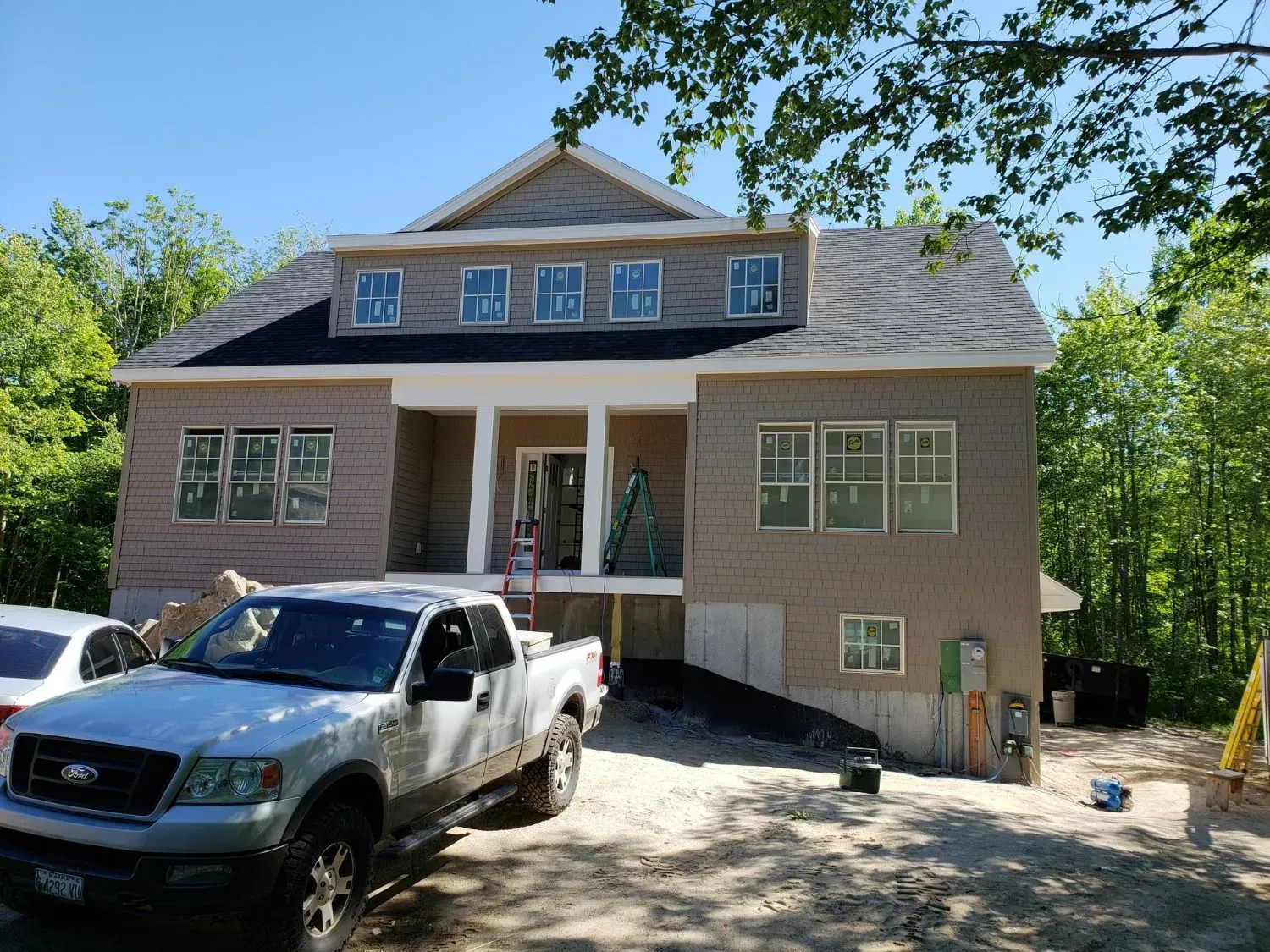 A truck is parked in front of a house under construction.