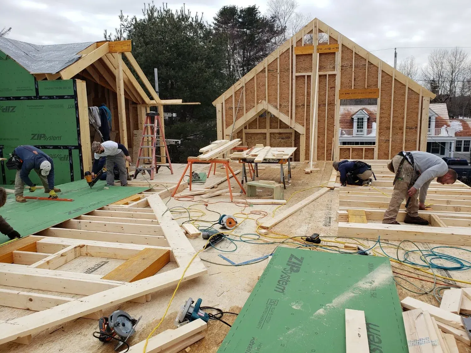 A group of construction workers are working on a house under construction.